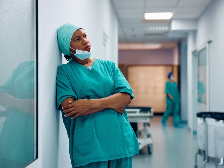 A clinical staff member stood in a corridor looking unhappy